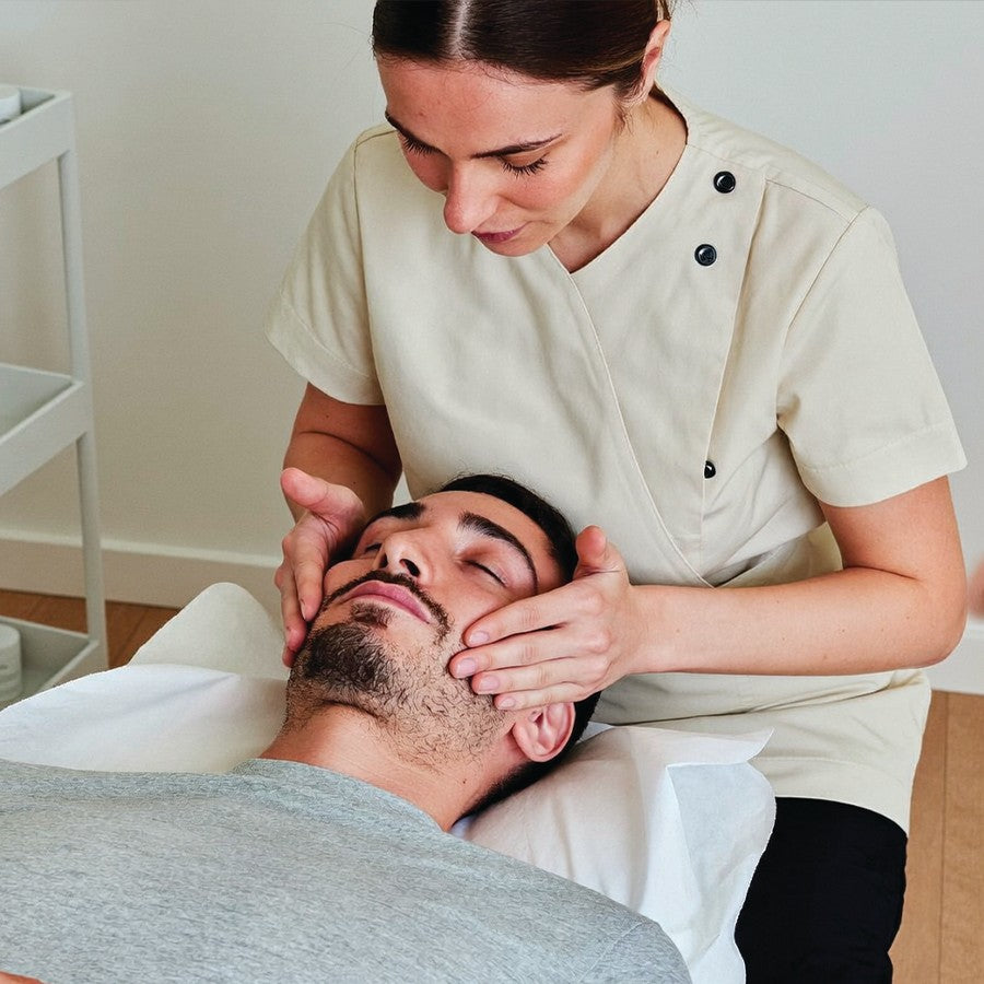 Modelage du visage à mains nues sur un homme en institut de beauté