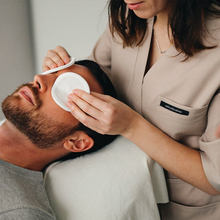 Nettoyage du visage d'un homme en cabine d'institut