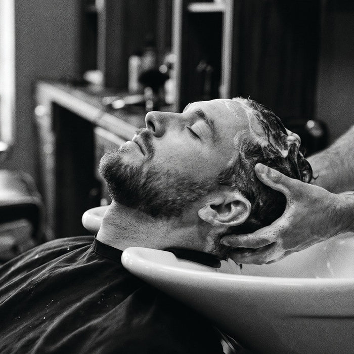 Shampoing au bac dans un salon de coiffure homme