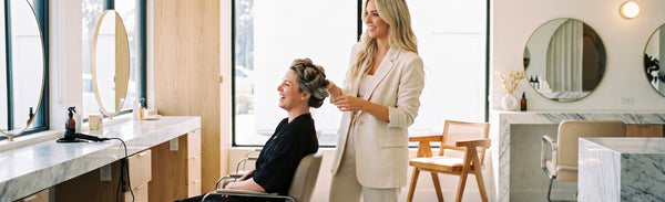 Coiffeuse et cliente dans un salon de coiffure lumineux